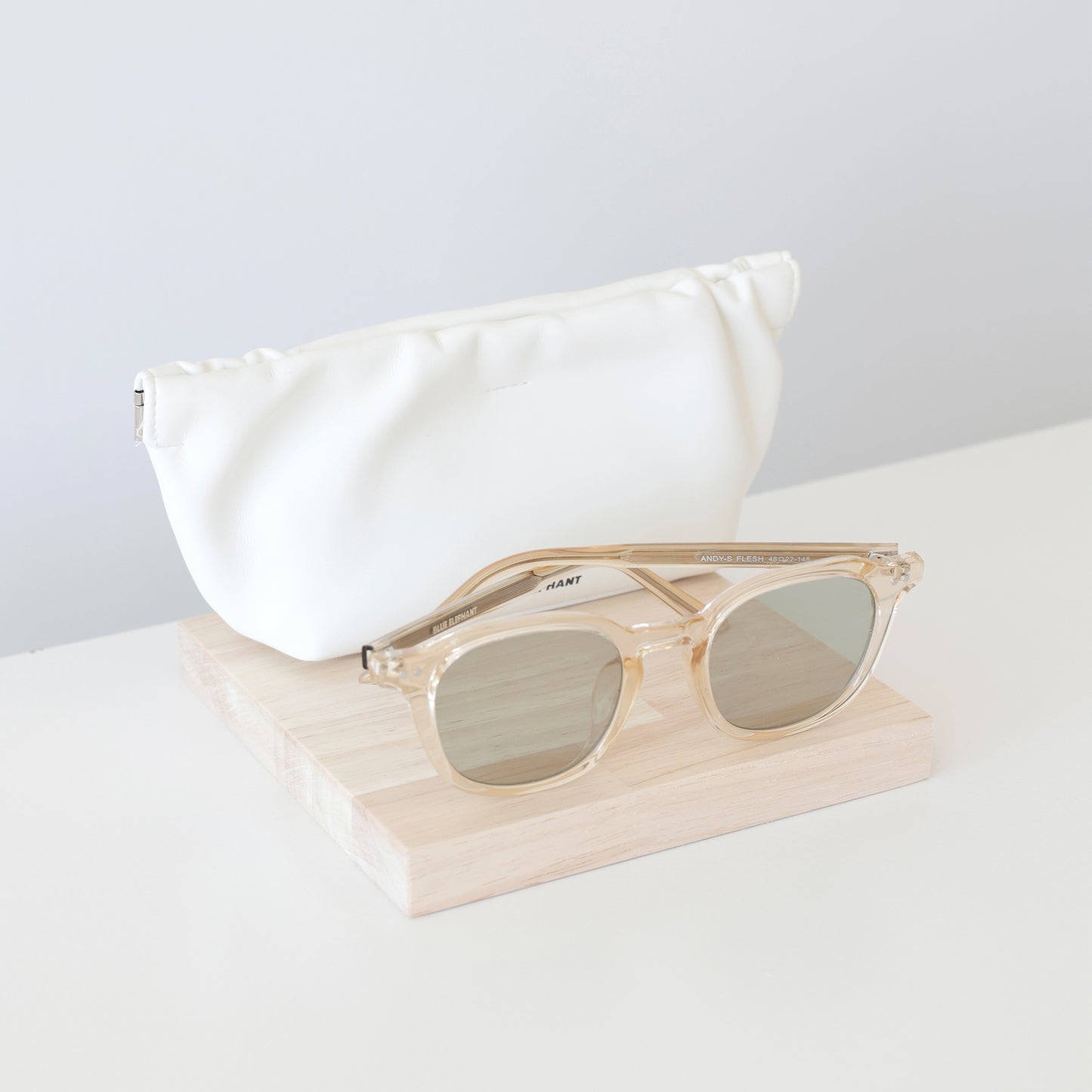 Plateaux en bois naturel de forme carrée, présentant des lunettes de soleil et un accessoire en boutique