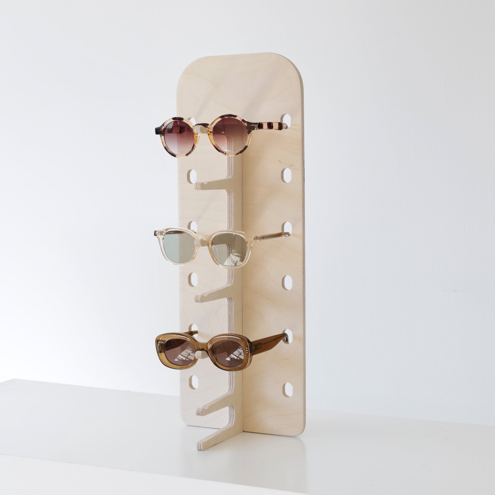 Présentoir à lunettes JAMIE en bois, affichant 6 paires de lunettes dans une boutique élégante.