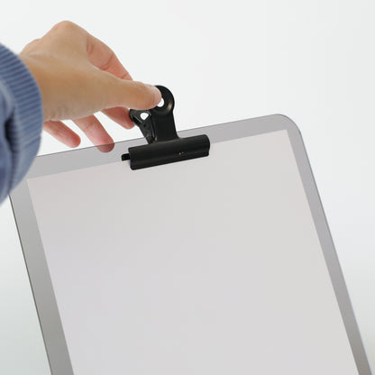 Support JOHN A4 en acrylique avec pince noire tenant une affiche, présenté sur une surface blanche.