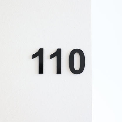 Numéro autocollant pour chambre, hôtel, maison d'hôtes, en acrylique noir en relief fixé sur une porte blanche.