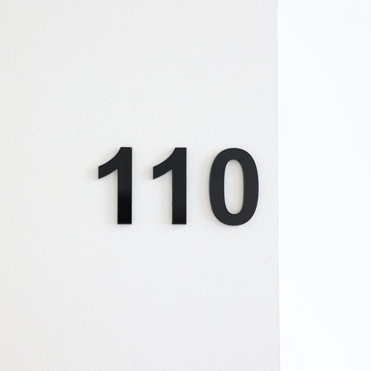Numéro autocollant pour chambre, hôtel, maison d'hôtes, en acrylique noir en relief fixé sur une porte blanche.