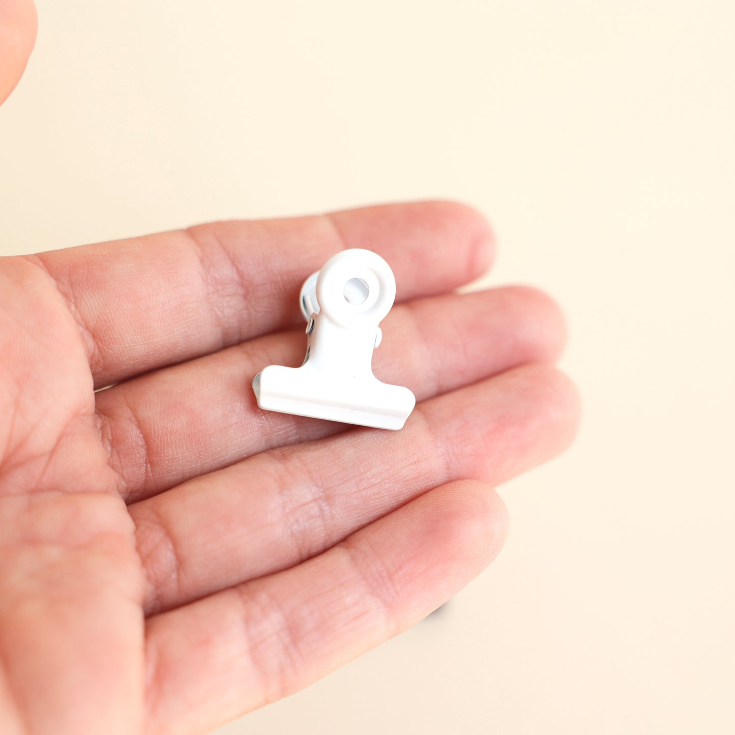 Pince métallique de couleur blanche adaptée aux modèles de présentoirs en acrylique Makk Design