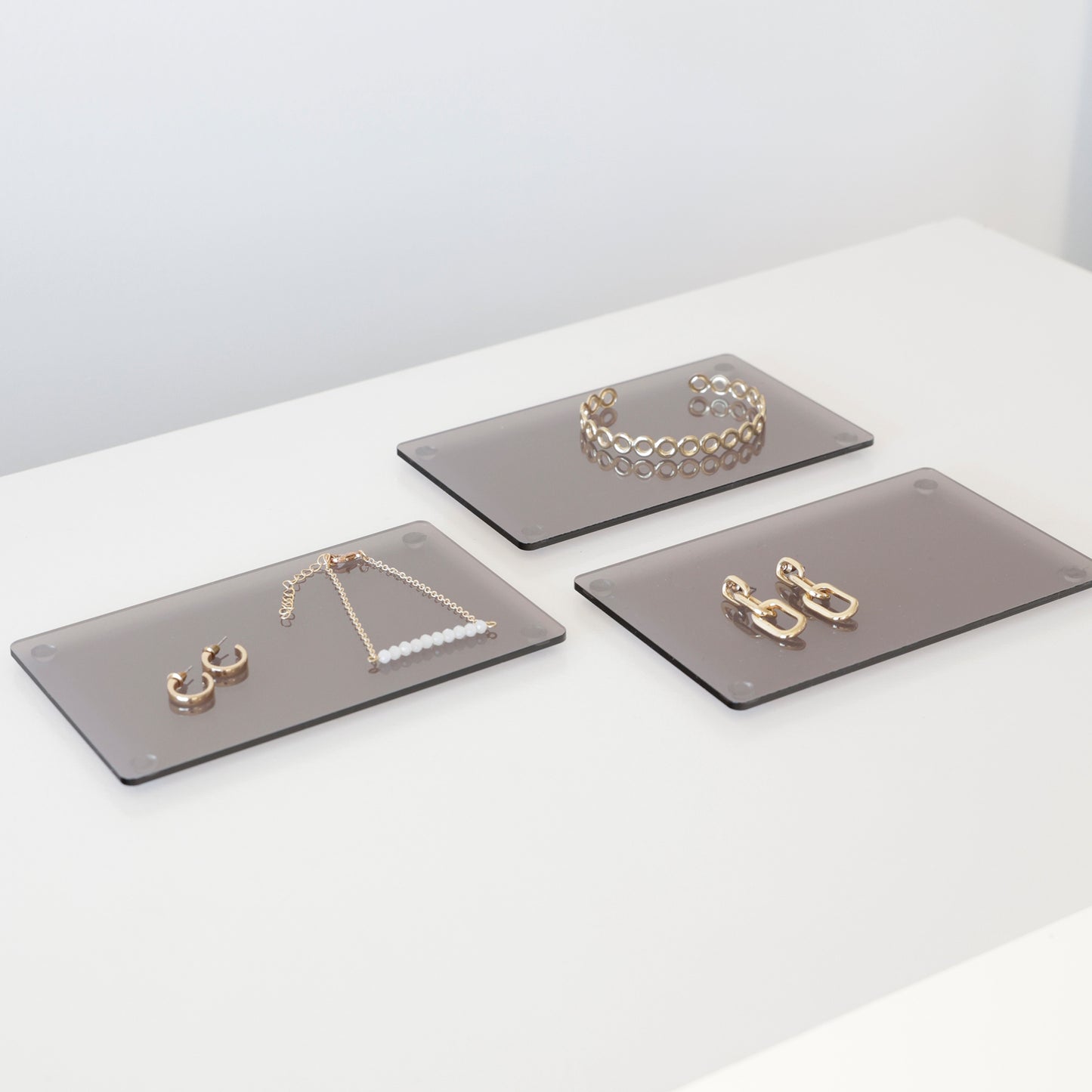 Plateaux en acrylique gris qui présentent des bijoux en magasin