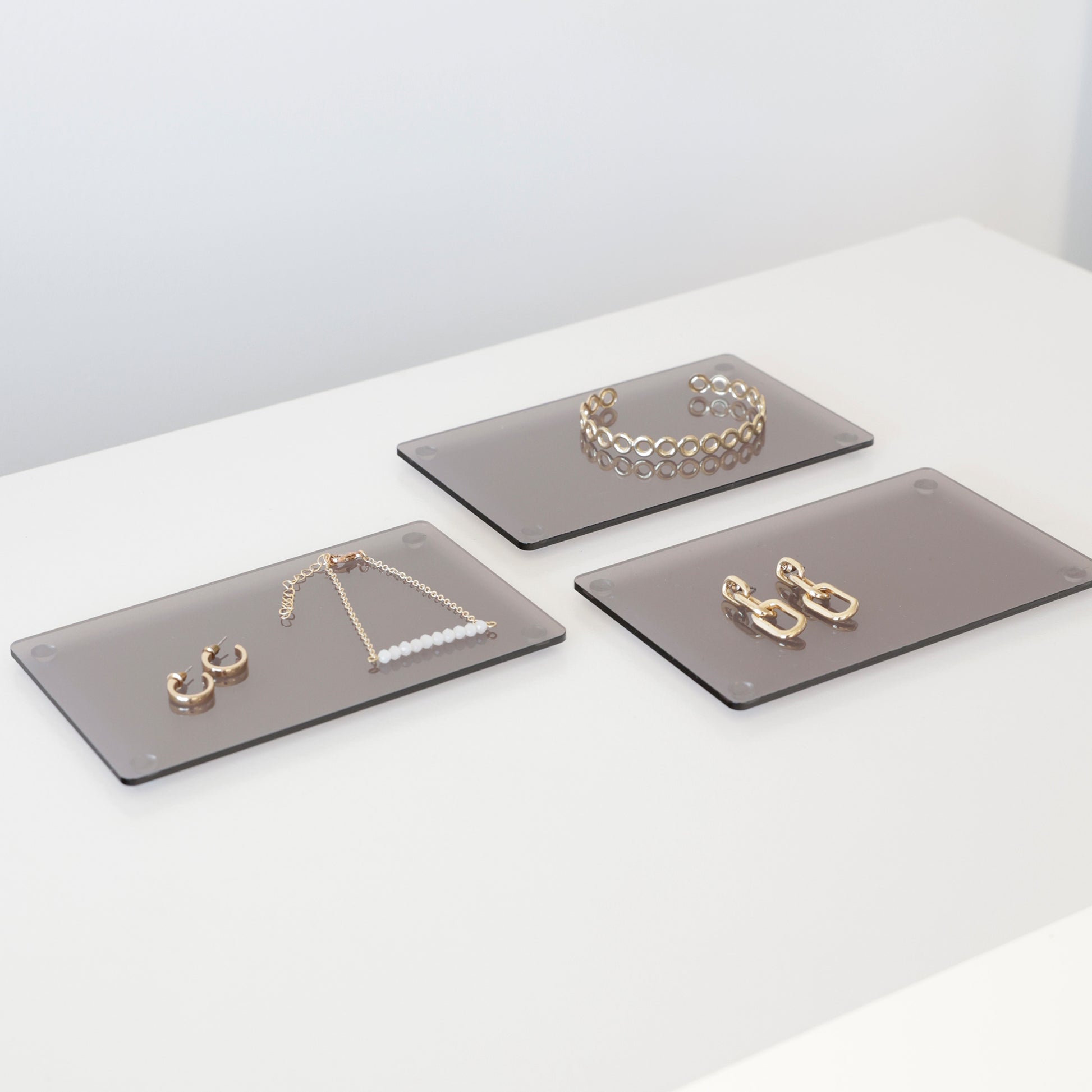 Plateaux en acrylique gris qui présentent des bijoux en magasin